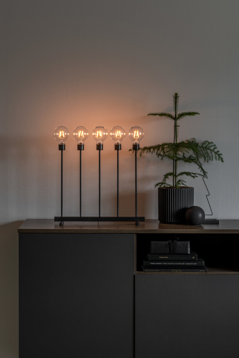 Konstsmide LED Metallleuchter auf einer Kommode