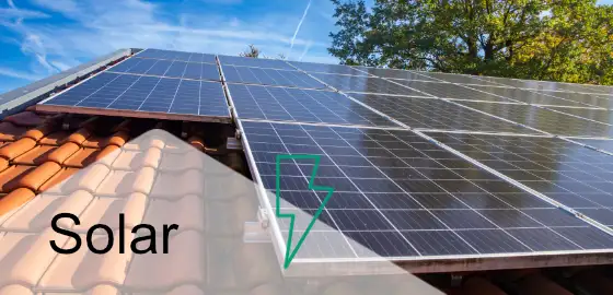 Hausdach mit Solarmodulen und Schriftzug Solar