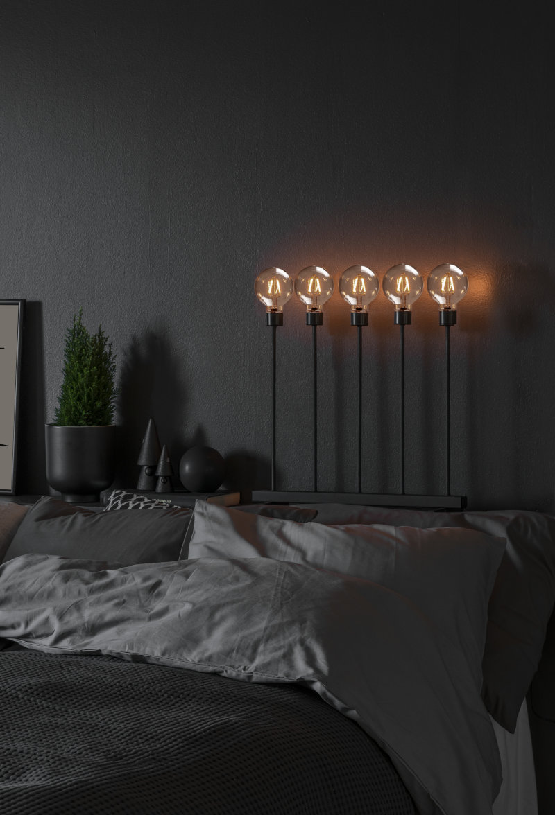 Konstsmide LED Metallleuchter auf einem Nachttisch